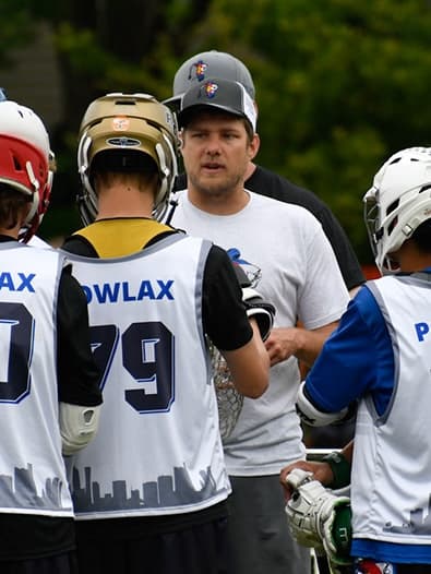Patrick Chapla coaching, talking to young players in POWLAX pinnies during a practice on the field